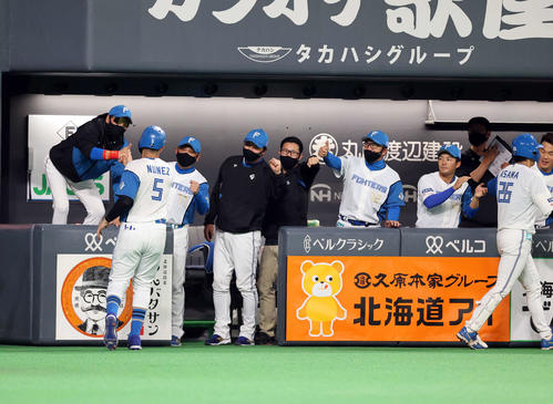 日本ハム対西武 2回裏日本ハム2死一塁、浅間(手前右)が右越え2点本塁打を放ち、BIGBOSSポーズで迎える新庄監督(左)(撮影・浅見桂子)