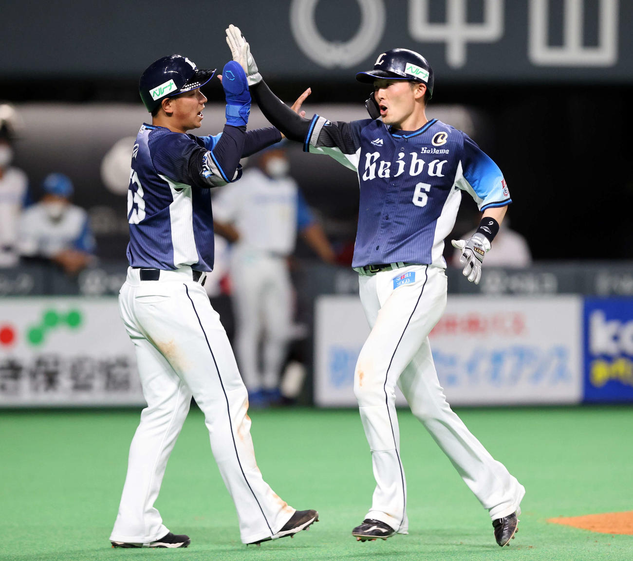 日本ハム対西武　5回表西武1死一、三塁、オグレディの左2点適時二塁打で生還した源田（右）は愛斗とハイタッチ（撮影・浅見桂子）