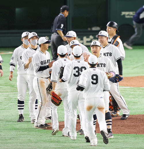 巨人対阪神　阪神に勝利し喜び合う巨人大城（右奥）、大勢（同手前）らナイン（撮影・垰建太）
