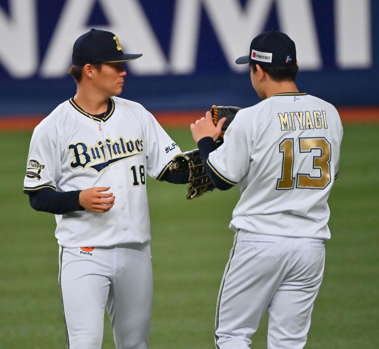 キャッチボールを終え、グラブタッチを交わす山本（左）と宮城（撮影・和賀正仁））
