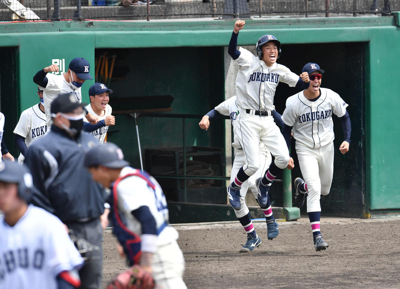 中大対国学院大　開幕戦に勝利し、ベンチから飛び出て喜ぶ古江主将（右から2人目）ら国学院大ナイン（撮影・岩下翔太）