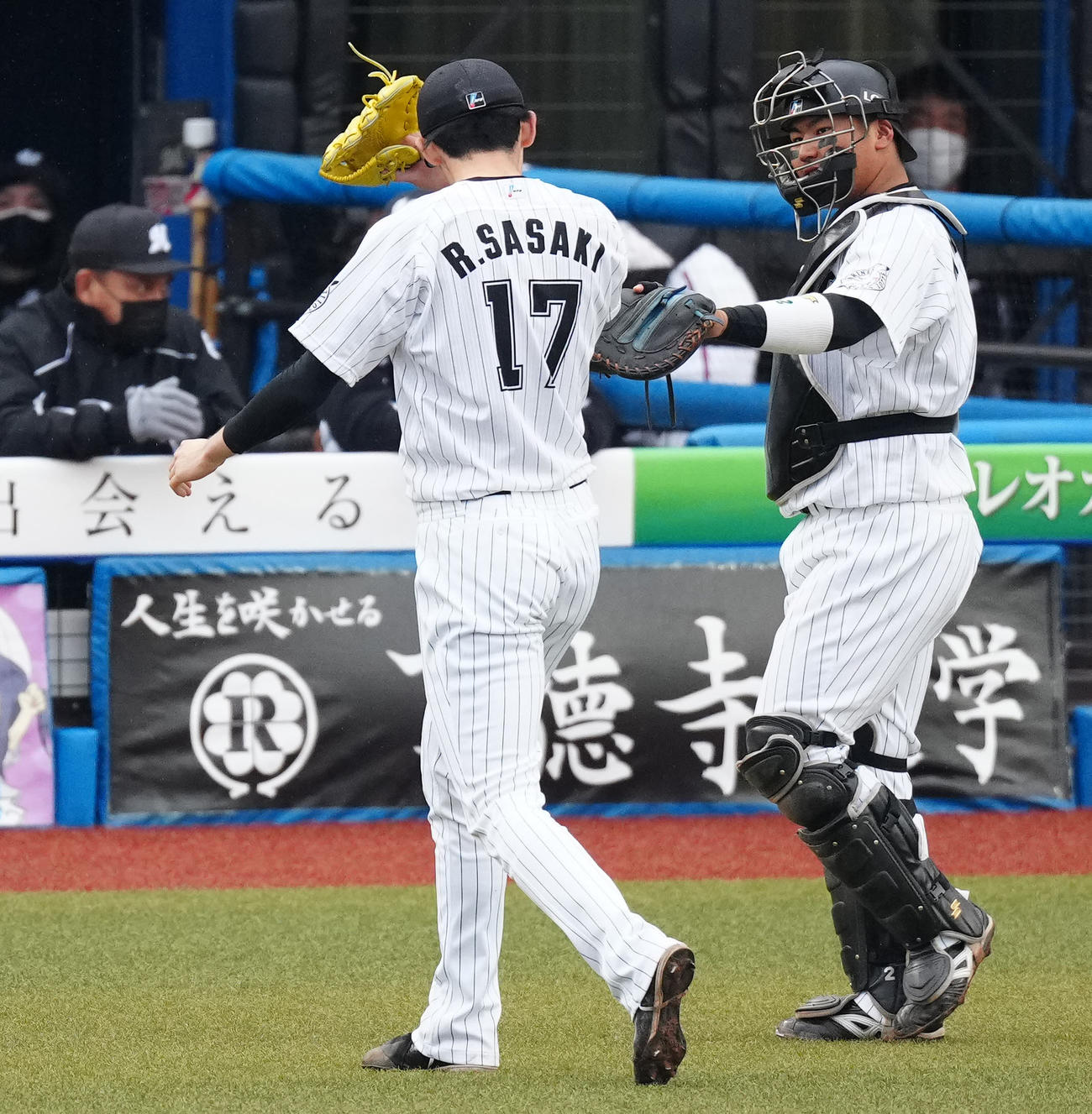 ロッテ対西武　8回表終了後、ロッテ先発の佐々木朗（左）とタッチをかわす捕手松川（撮影・江口和貴）