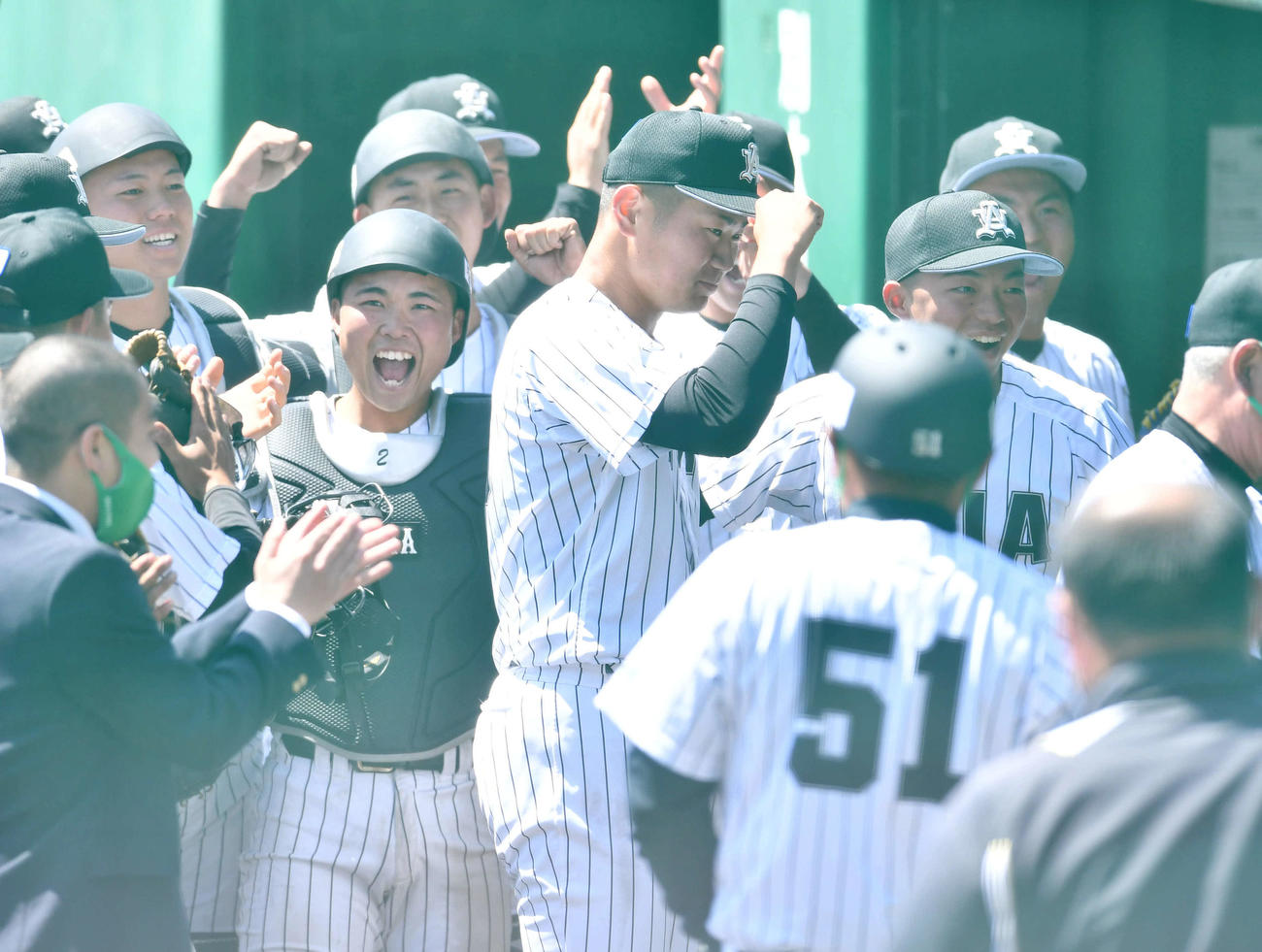 亜大対駒大　完封勝利を挙げた青山（中央）は、ベンチ前で亜大ナインから祝福される（撮影・岩下翔太）