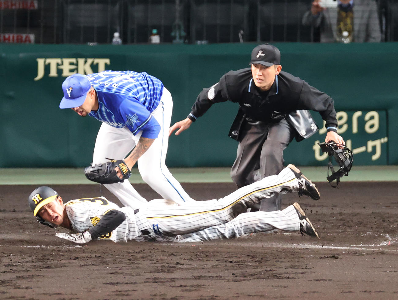 阪神対DeNA 2回裏阪神1死三塁、打者近本の時、ロメロ（左から2人目）の暴投の間に生還する三走小幡（左）（撮影・上山淳一）