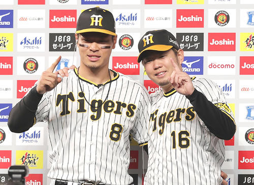 お立ち台で笑顔でポーズを決める阪神佐藤輝明(左)と西勇輝(撮影・前田充)