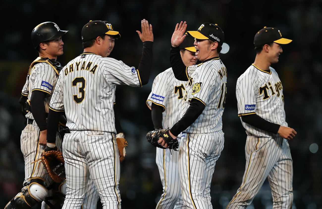 阪神対DeNA　今季初勝利を挙げ、タッチを交わして喜ぶ大山（左から2人目）と西勇（同4人目）ら阪神ナイン（撮影・前田充）
