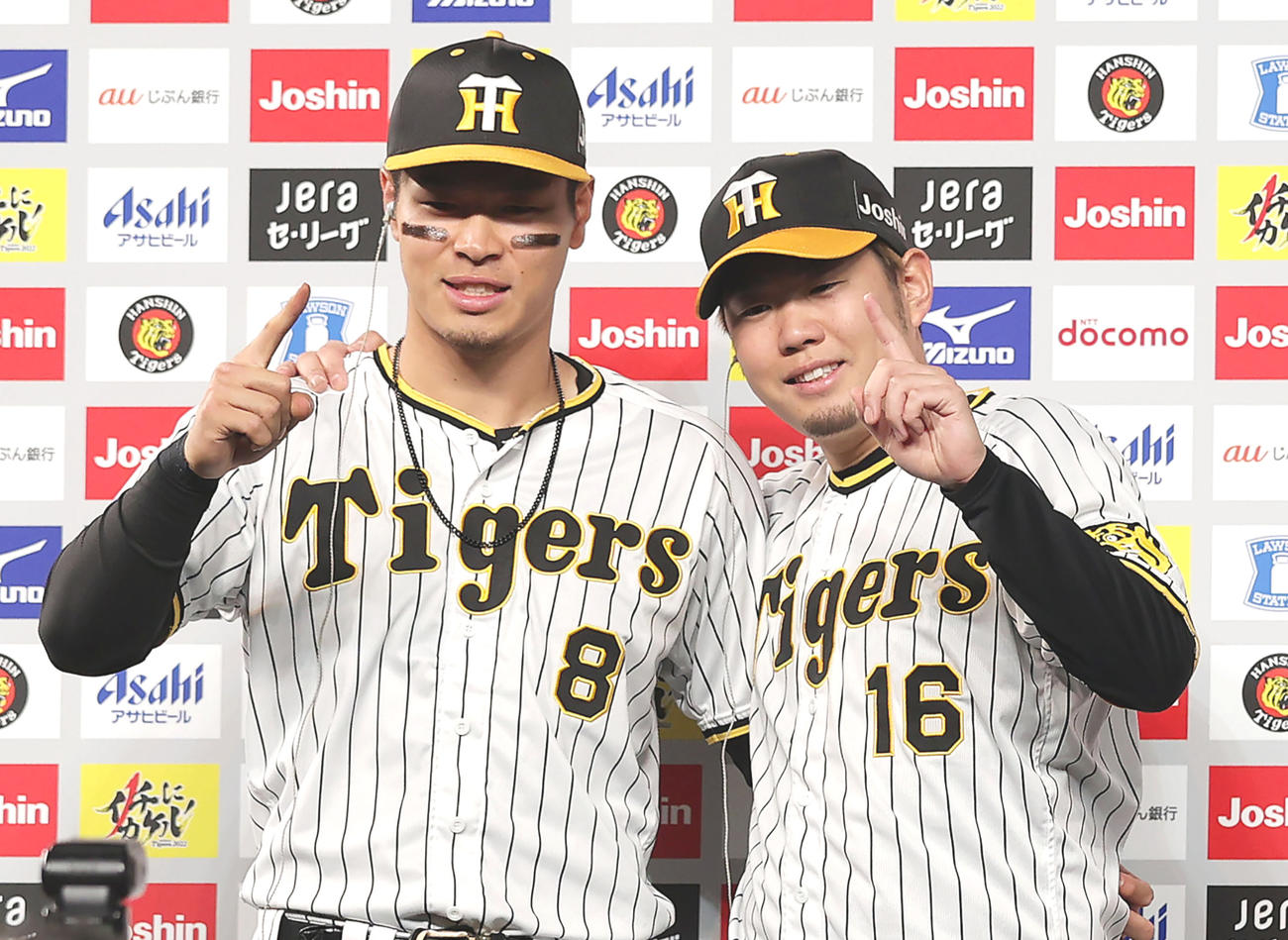 お立ち台で笑顔でポーズを決める阪神佐藤輝明（左）と西勇輝（撮影・前田充）