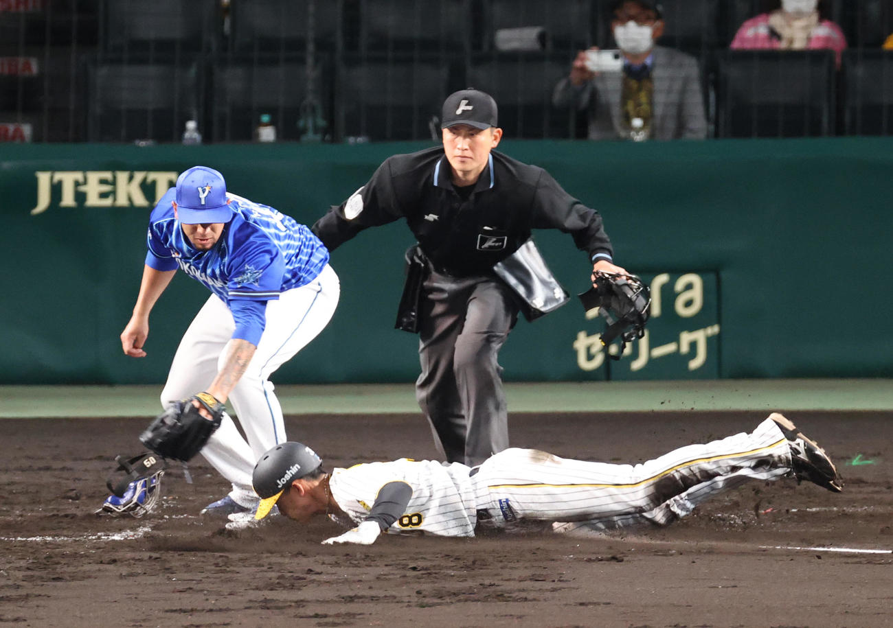 阪神対DeNA 2回裏阪神1死三塁、打者近本の時、ロメロ（左）の暴投で生還する三走小幡（撮影・上山淳一）