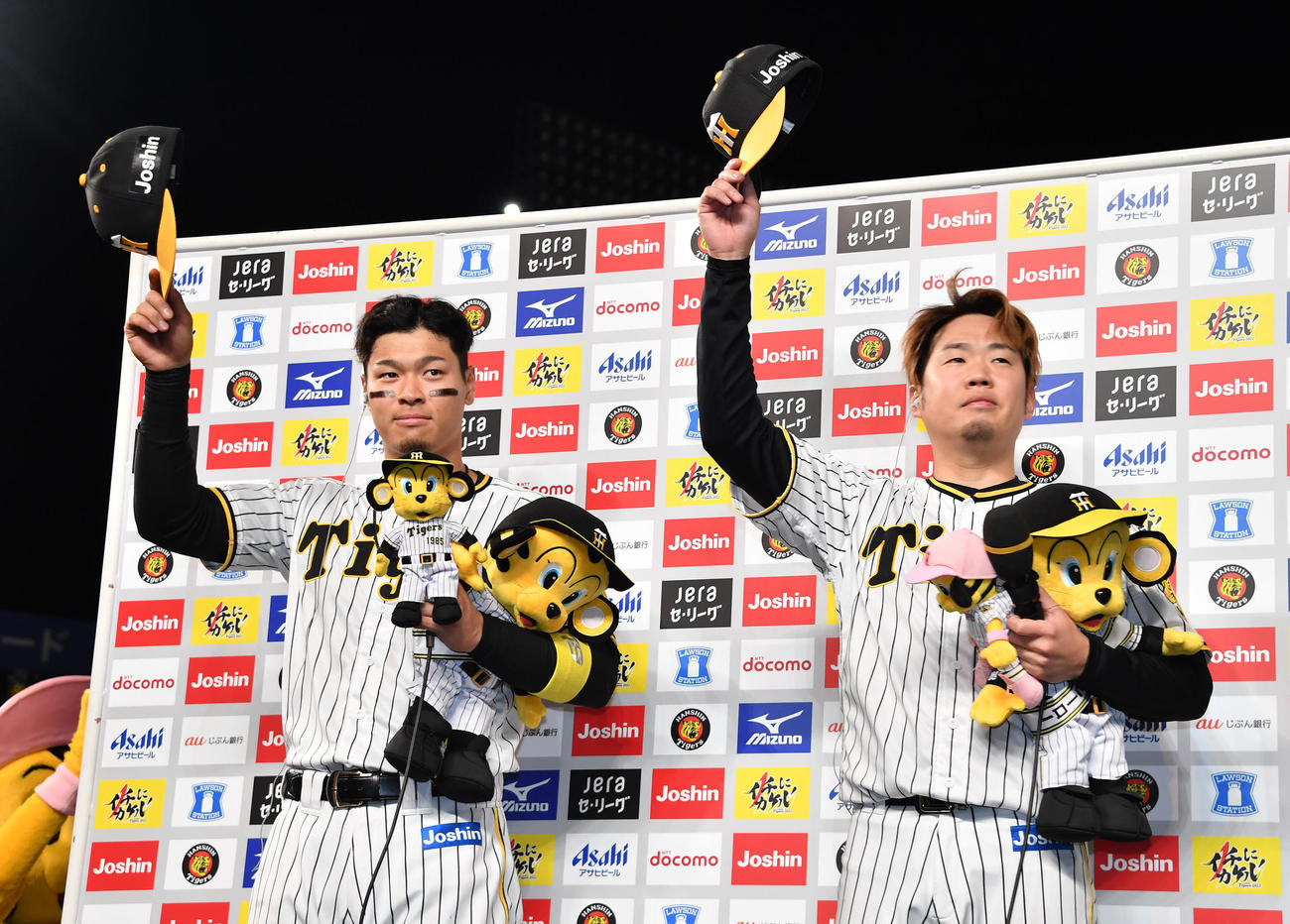 阪神対DeNA　ヒーローインタビューのあとで帽子を取って観客に応える佐藤輝（左）と西勇（代表撮影）