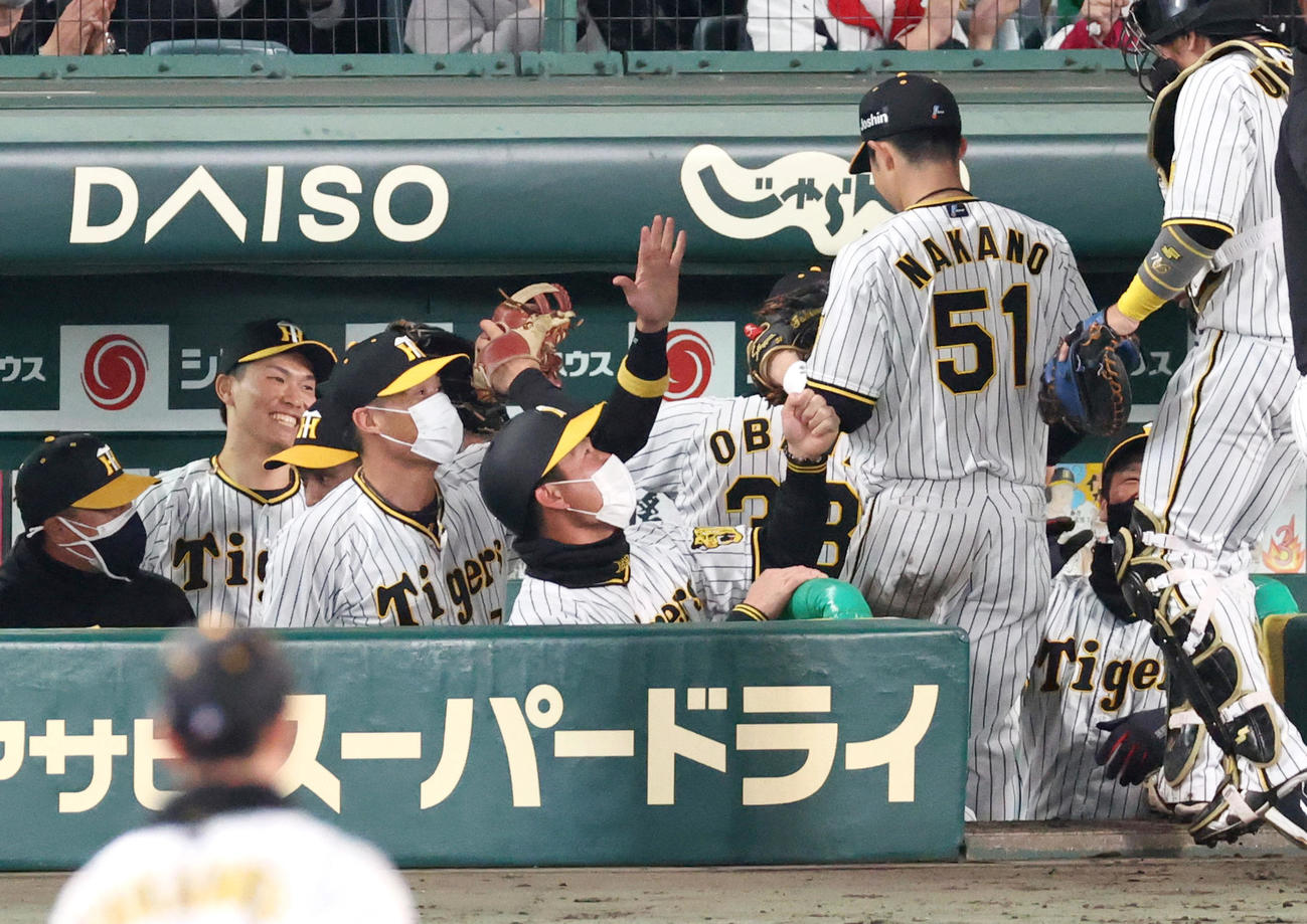 阪神対DeNA 11回に登板の湯浅（左から2人目）はピンチを無失点で終えベンチで笑顔を見せる（撮影・上山淳一）