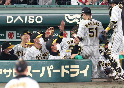 阪神対DeNA 11回に登板の湯浅(左から2人目)はピンチを無失点で終えベンチで笑顔を見せる(撮影・上山淳一)