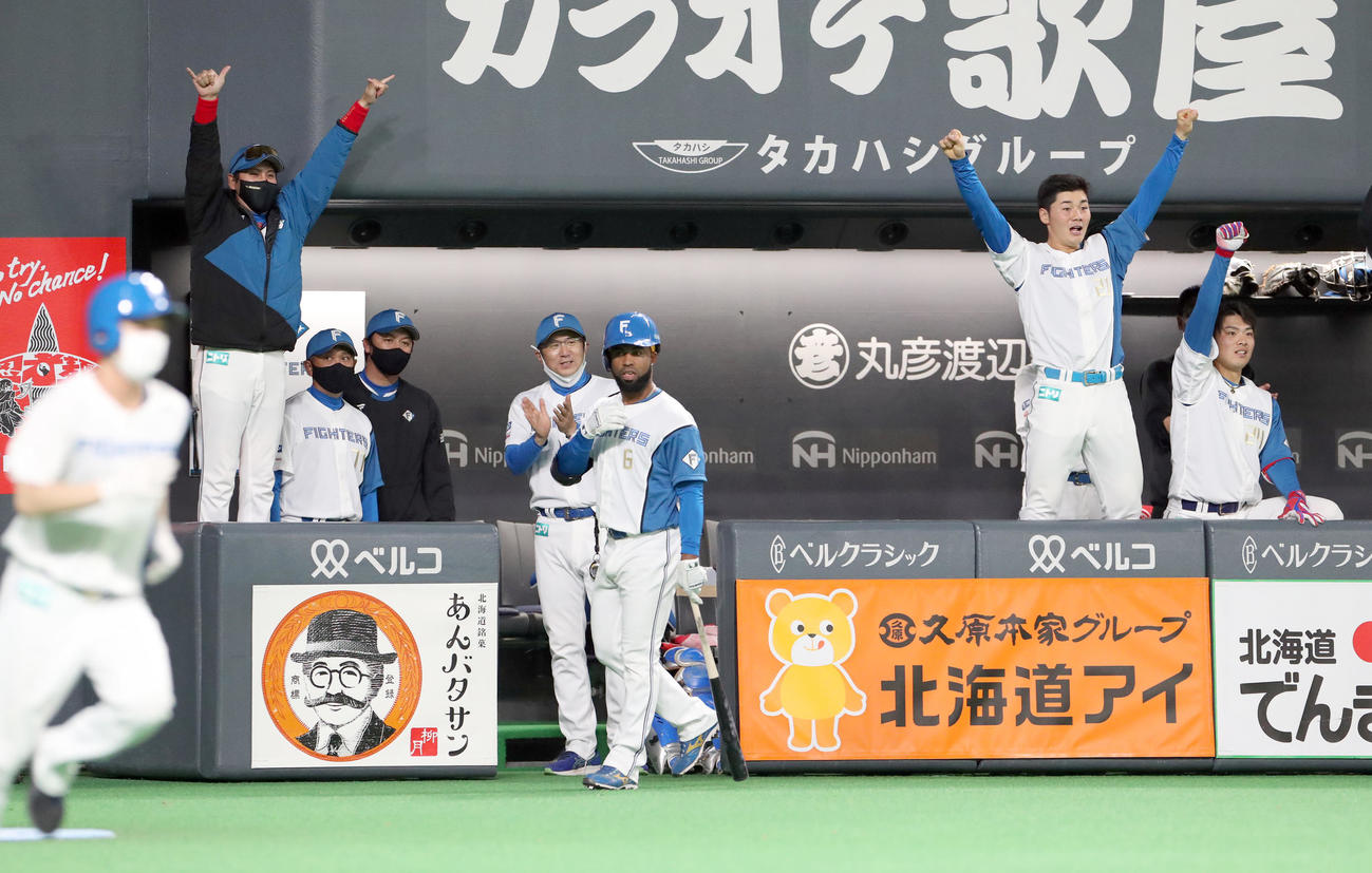 日本ハム対ロッテ　9回裏日本ハム無死一塁、石井の右前打で手を上げて喜ぶ新庄監督（左）。右から野村、清宮（撮影・佐藤翔太）