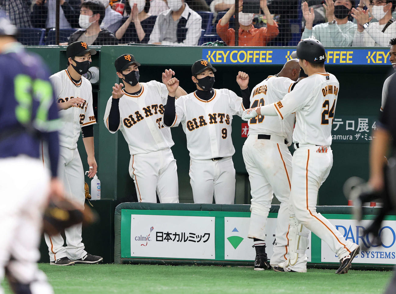 巨人対ヤクルト　4回裏巨人2死、大城（手前右）の中越えソロ本塁打を迎える選手たち（撮影・鈴木正人）