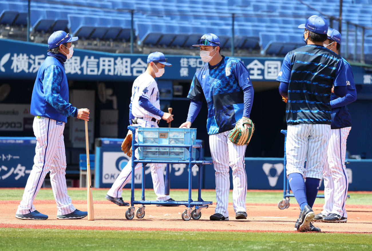 ノック練習を前に石井コーチ（左）と話すDeNA佐野（同3人目）ら野手陣（撮影・丹羽敏通）