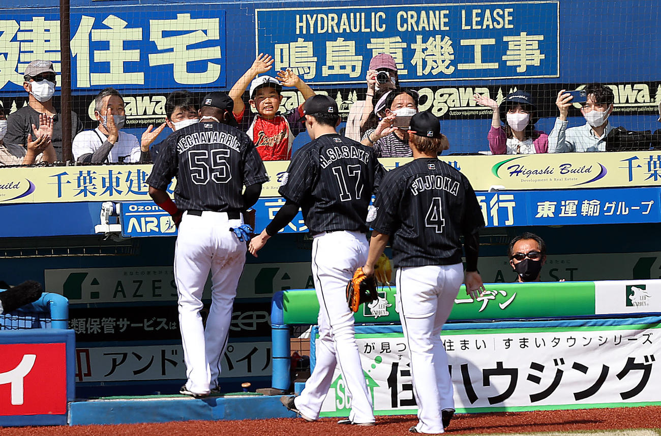 ロッテ対オリックス　1回表を終え、子どもファンに迎えられるロッテ先発の佐々木朗（中央）（撮影・狩俣裕三）