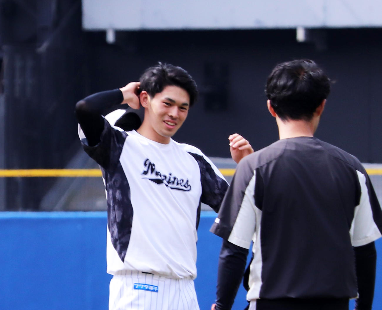 練習中にリラックスした表情を見せるロッテ佐々木朗希（左）（撮影・古川真弥）