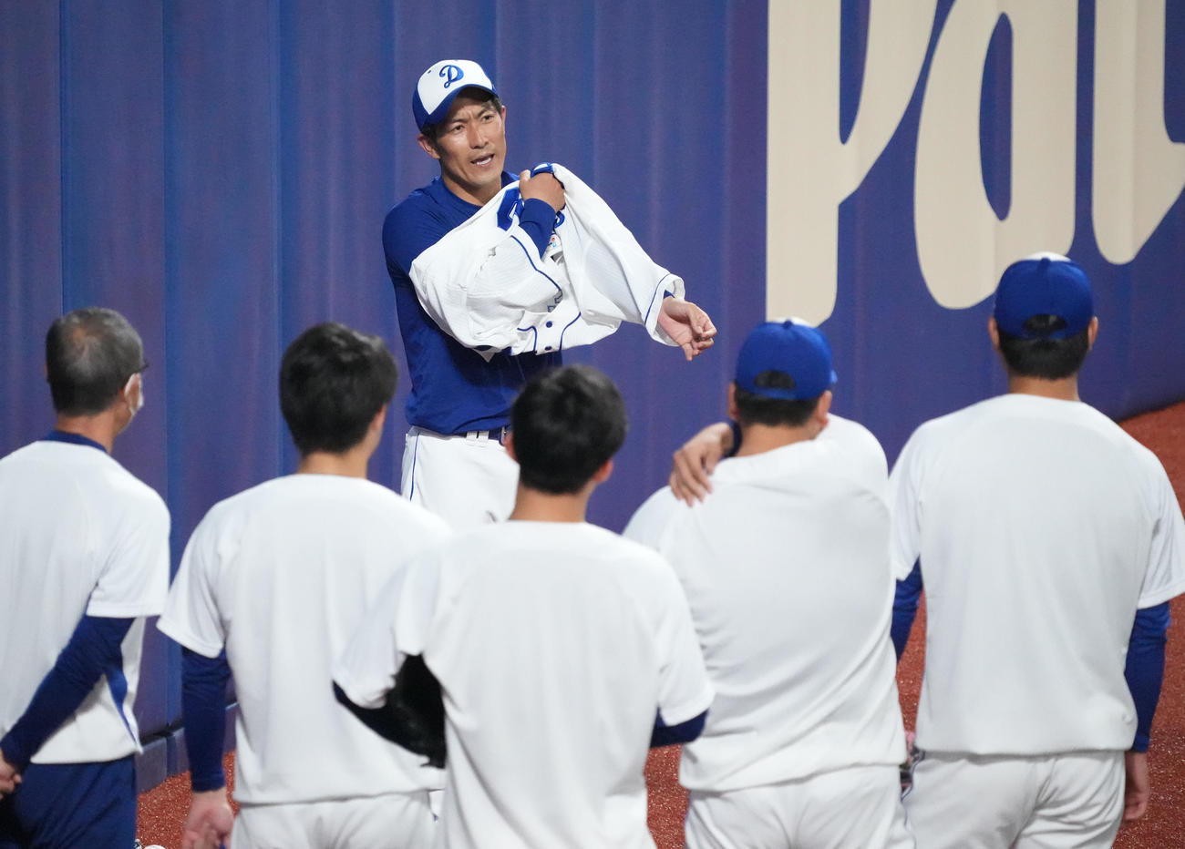 ナインにあいさつをしユニホームを着る祖父江（撮影・森本幸一）