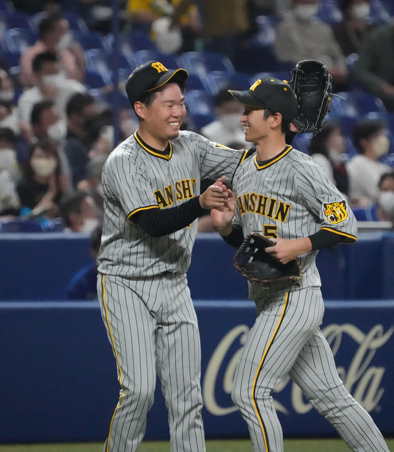 中日対阪神　3回裏中日2死一、二塁、西勇（左）はビシエドの打球を好捕した近本を笑顔で迎える（撮影・森本幸一）