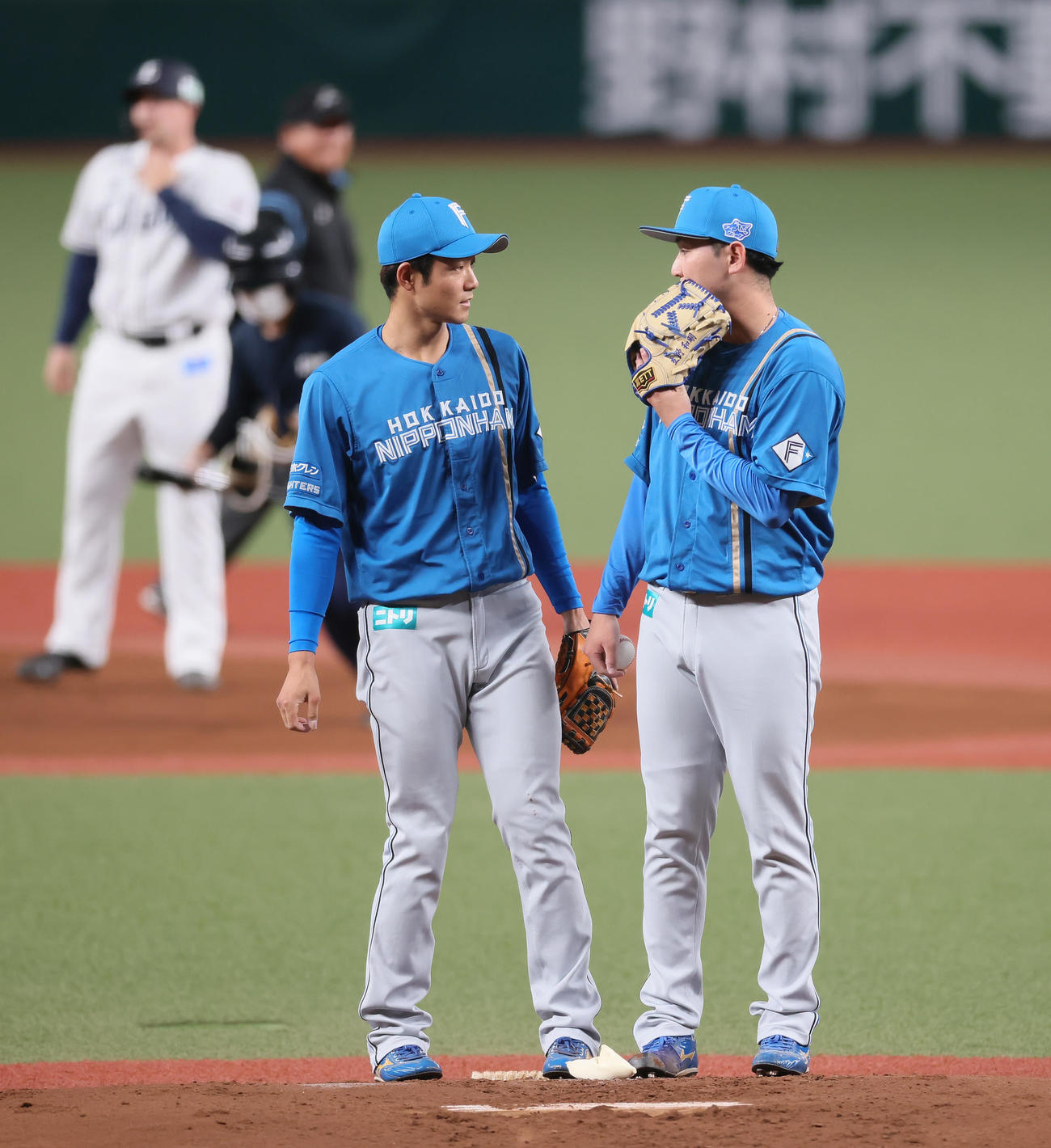 西武対日本ハム　1回裏西武1死一塁、オグレディ（後方左）に右越え適時二塁打を浴び、石井（左）と話す立野（撮影・足立雅史）