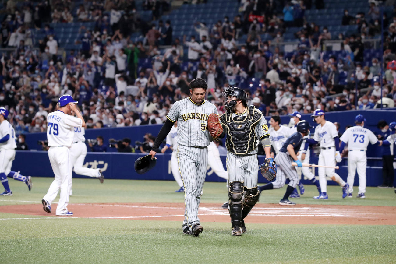 中日対阪神　10回裏中日1死一、二塁、加治屋（左）は大島にサヨナラ適時打を浴びて引き揚げる。右は梅野（撮影・加藤哉）