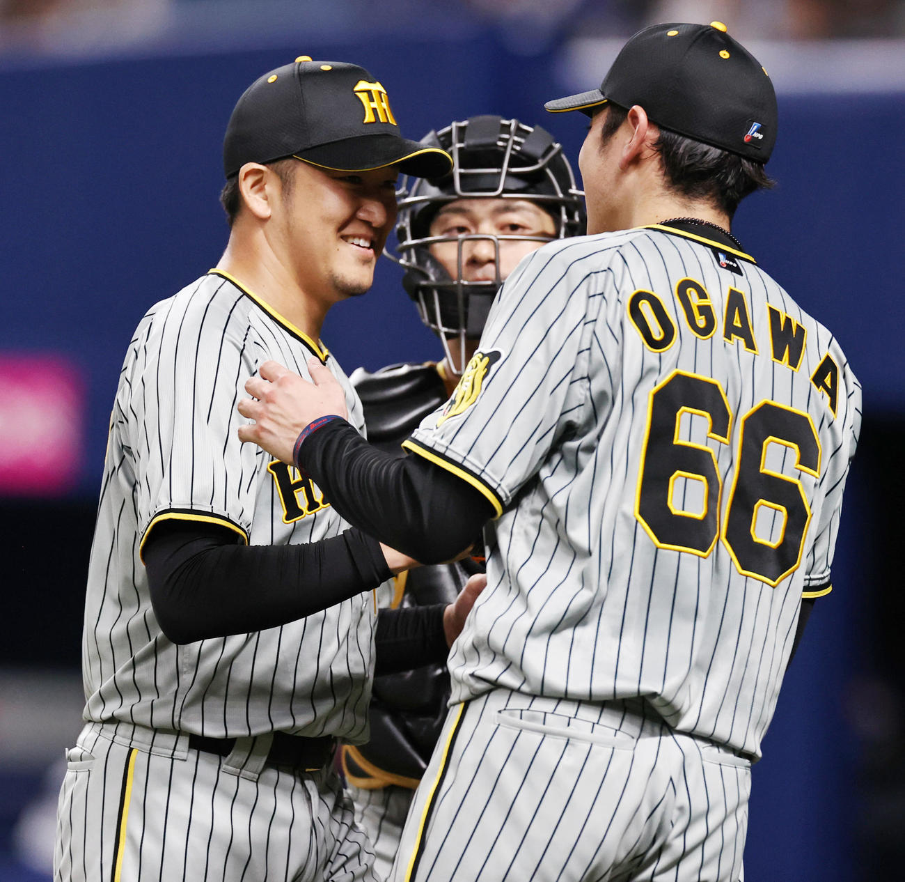 中日対阪神　5回裏、阪神2番手で登板し後続を抑えた岩貞（左）はベンチで小川の出迎えを受ける（撮影・加藤哉）