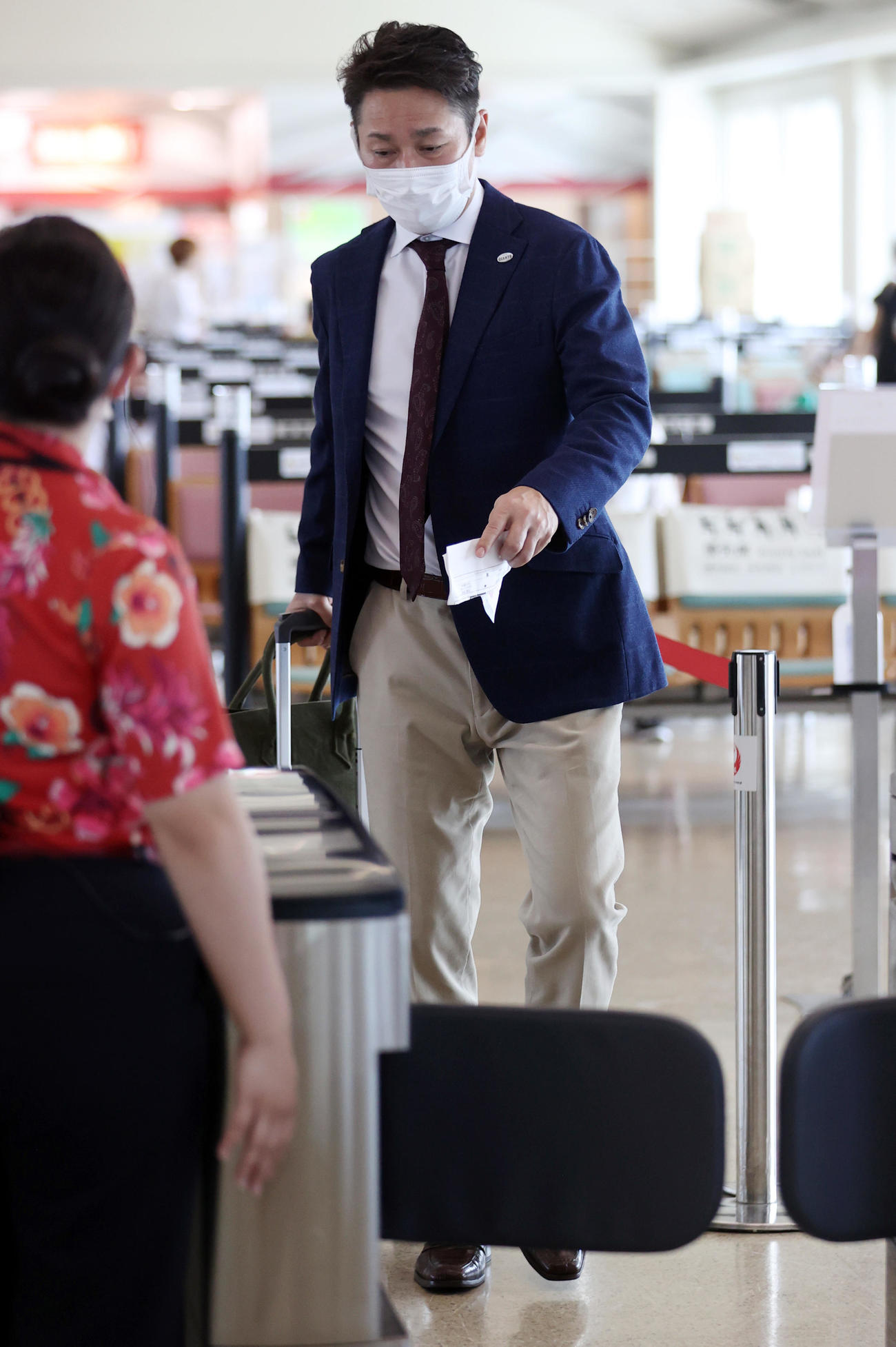 那覇空港から搭乗する巨人元木ヘッド兼オフェンスチーフコーチ（撮影・狩俣裕三）