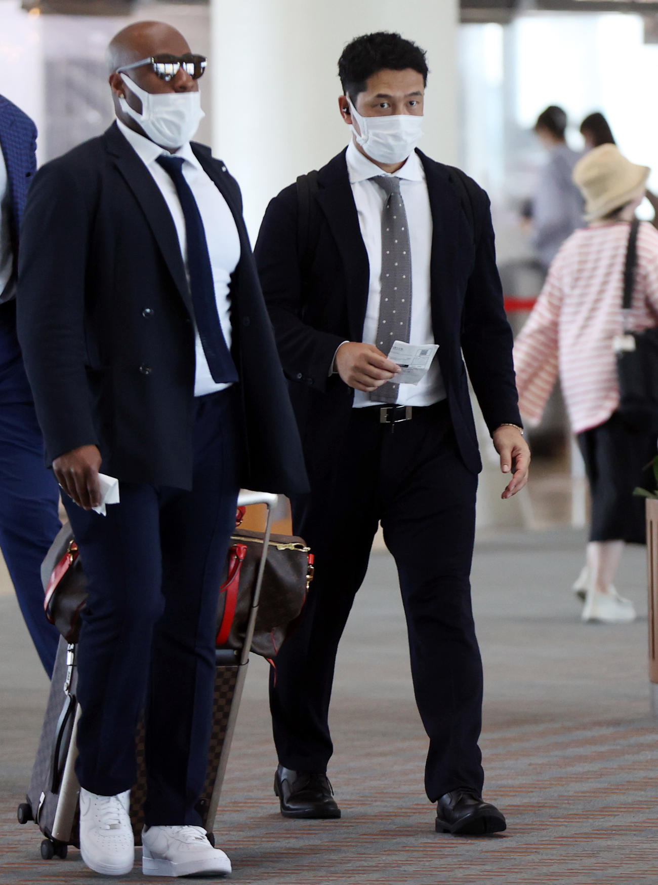 那覇空港から伊搭乗する巨人中島（右）。左はウィーラー（撮影・狩俣裕三）
