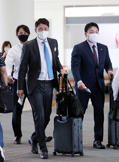 那覇空港から搭乗する巨人坂本（中央）。左は小林、右は丸（撮影・狩俣裕三）