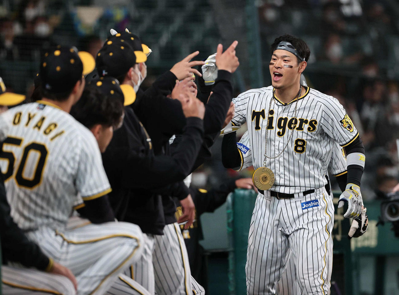 阪神対巨人　5回裏阪神2死二塁、右越えに逆転本塁打を放ちナインの本塁打出迎えを受ける佐藤輝（撮影・上田博志）