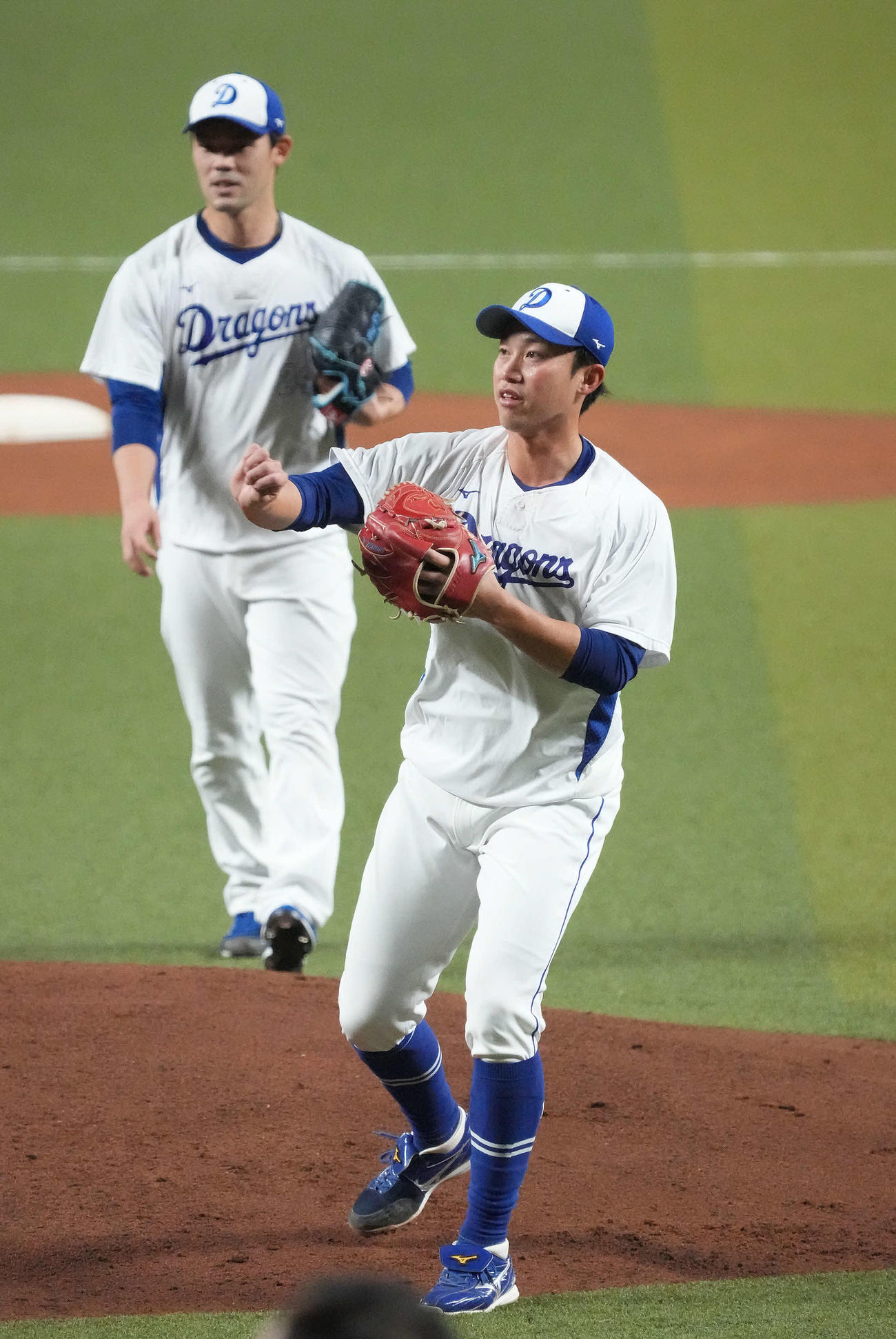 ノックを受ける中日岡野（手前）。奥は福谷（撮影・森本幸一）