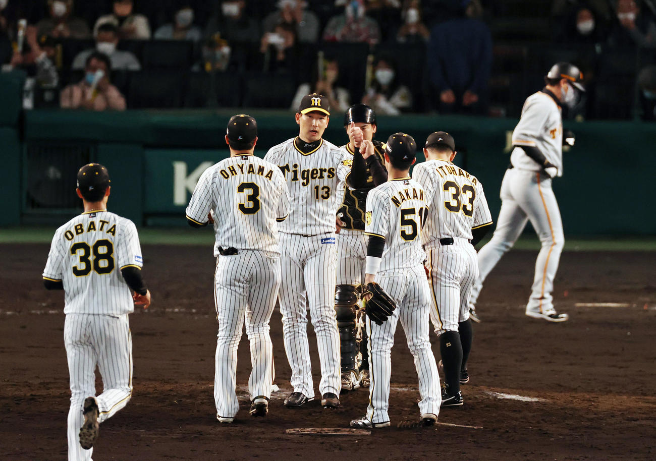 阪神対巨人　巨人に勝利しマウンドでナインとタッチする阪神岩崎（撮影・加藤哉）