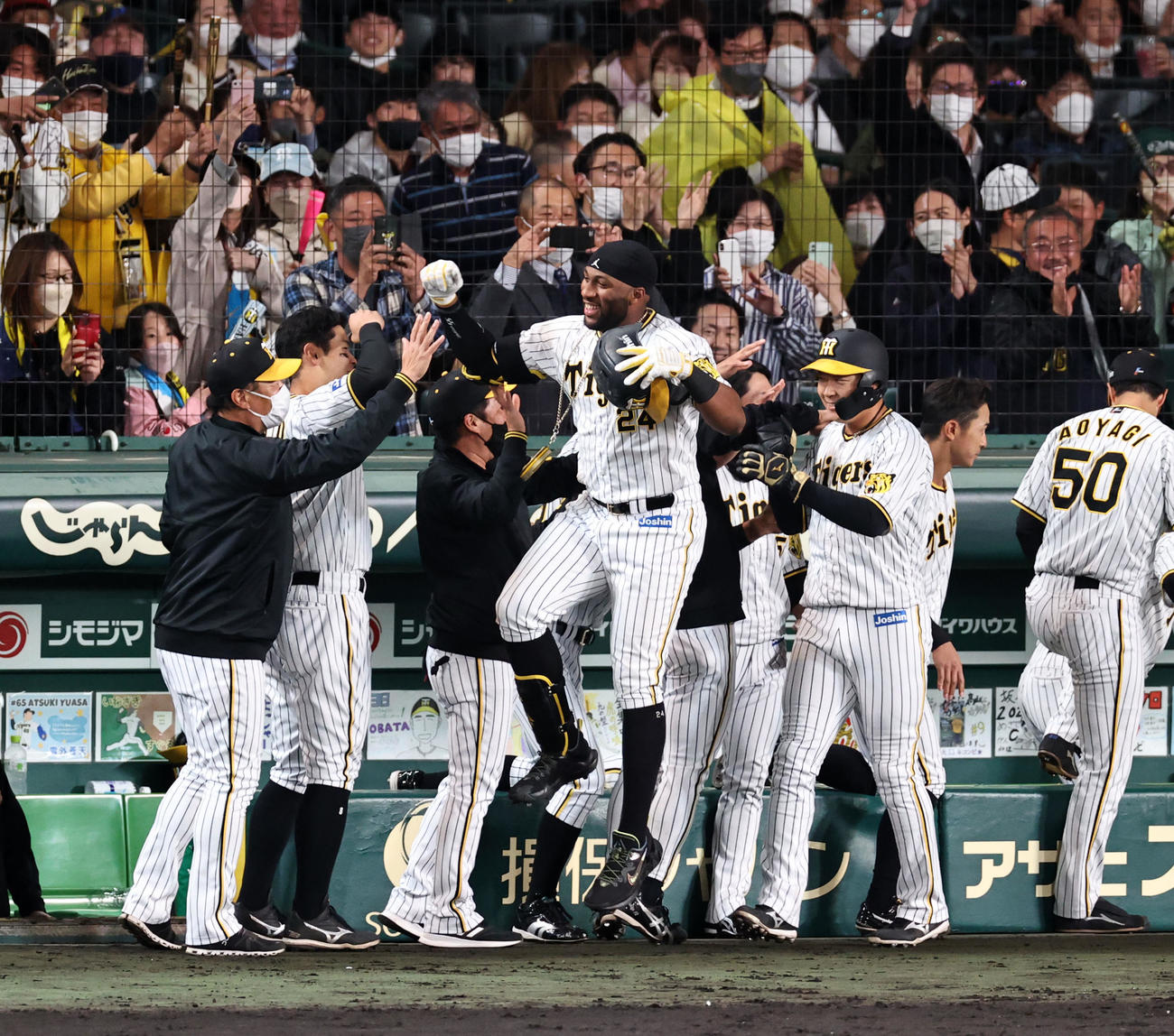 阪神対巨人　8回裏阪神無死一塁、ロハスは中越え2点本塁打を放ちベンチ前でナインと笑顔のタッチ（撮影・加藤哉）
