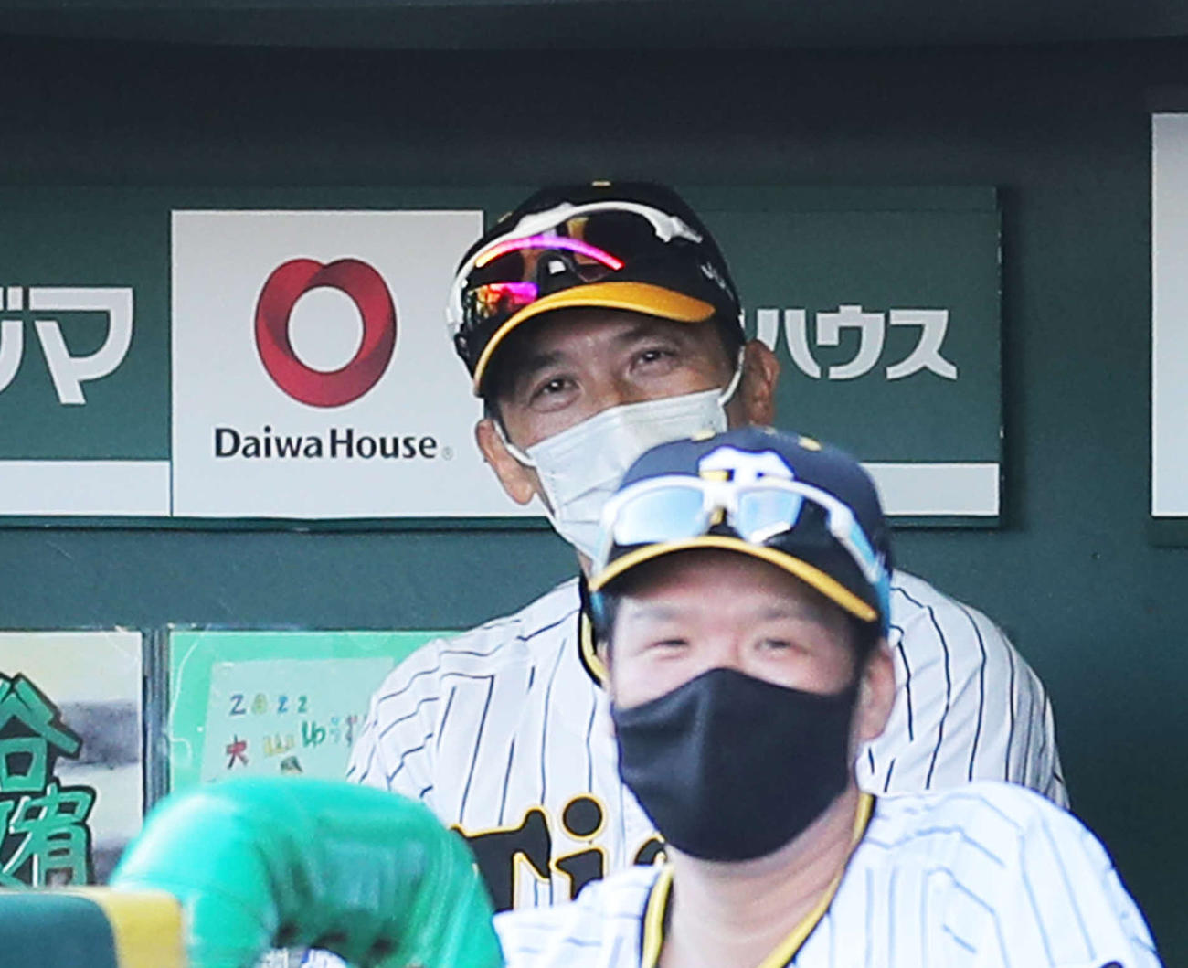 阪神対巨人　9回表、ベンチで笑みを浮かべる矢野監督（奥）（撮影・河田真司）