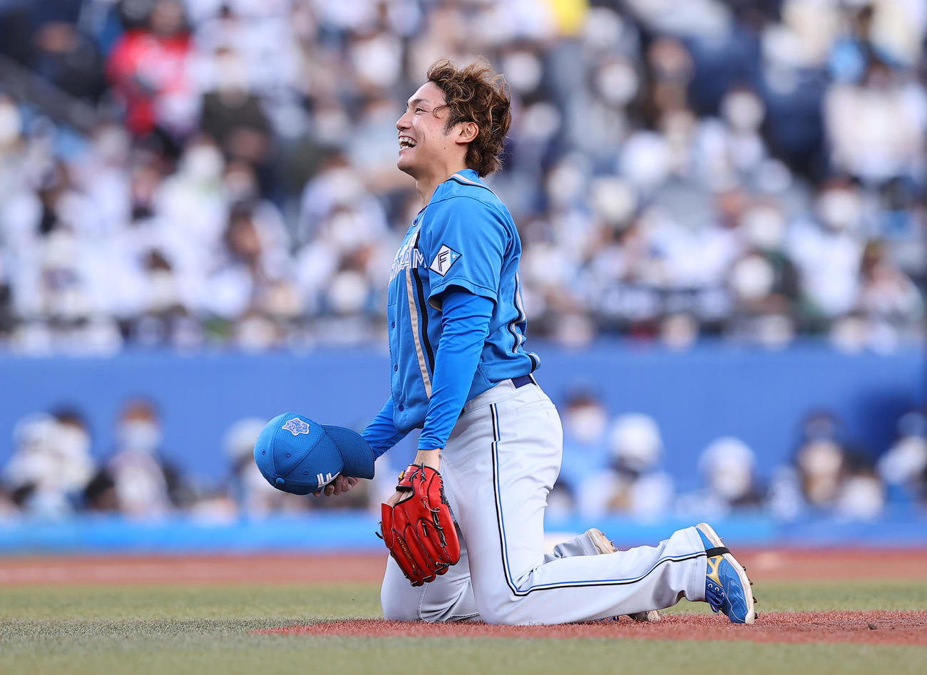 ロッテ対日本ハム　5回裏ロッテ2死一塁、打者レアードの時、ボールの判定に思わず笑顔で崩れ落ちる伊藤（撮影・垰建太）
