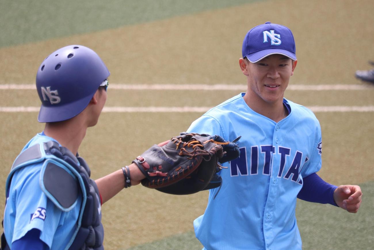 グローブ同士でハイタッチを交わす、日体大・矢沢宏太投手（撮影・阿部泰斉）