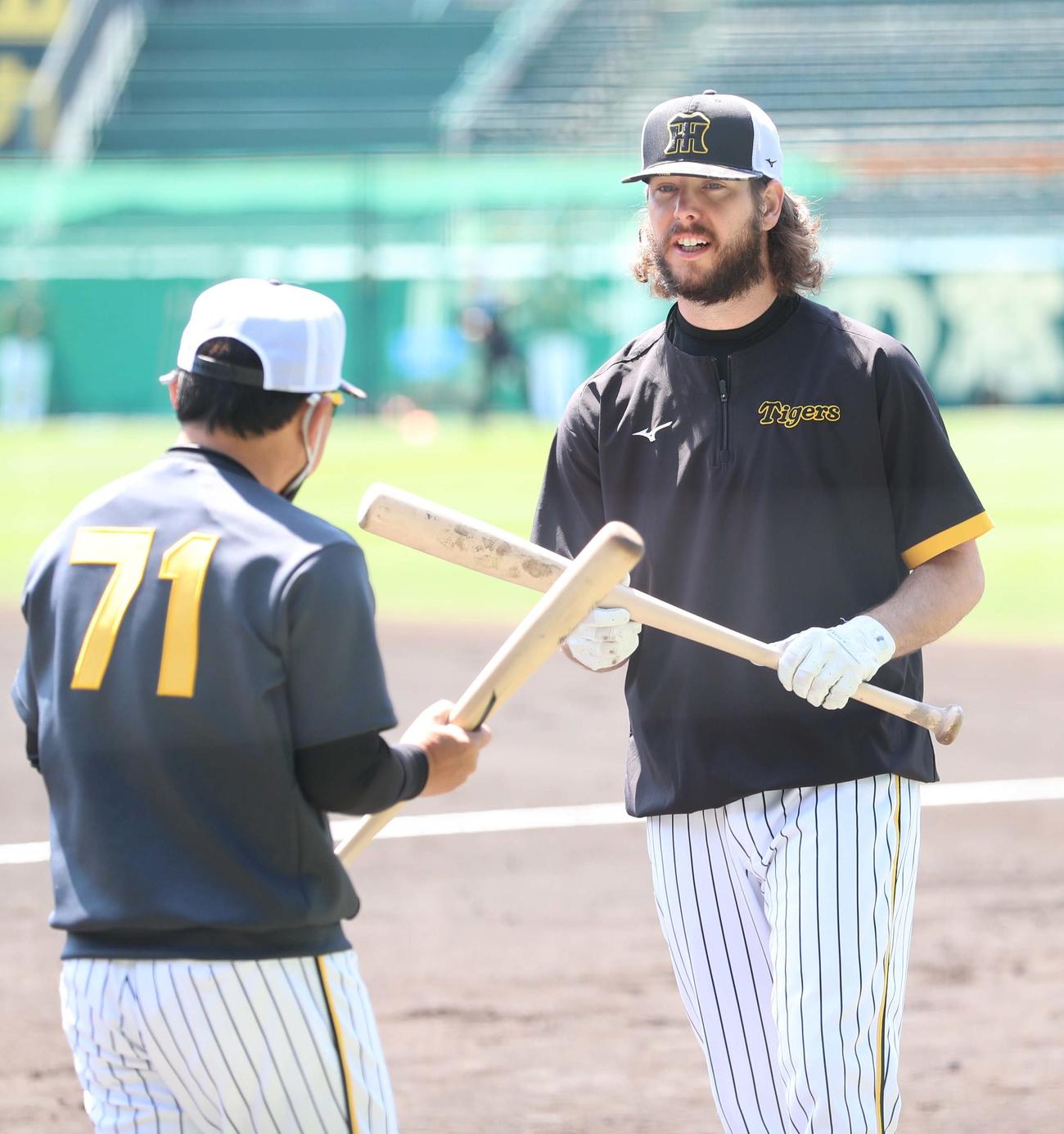 阪神対巨人　久慈コーチ（左）からバントの指導を受けるウィルカーソン（撮影・上田博志）