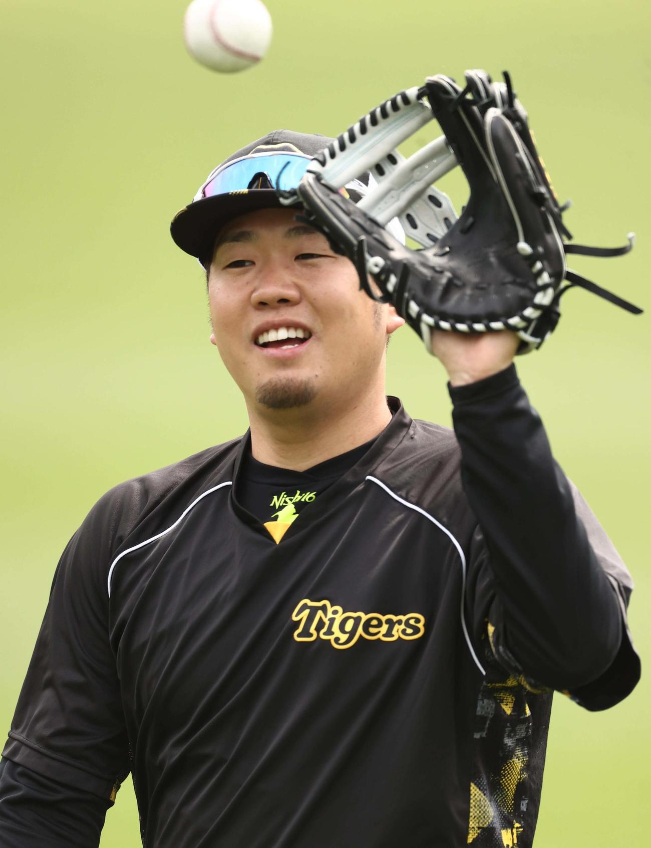 西勇輝は笑顔を見せながらキャッチボールをする（撮影・上田博志）