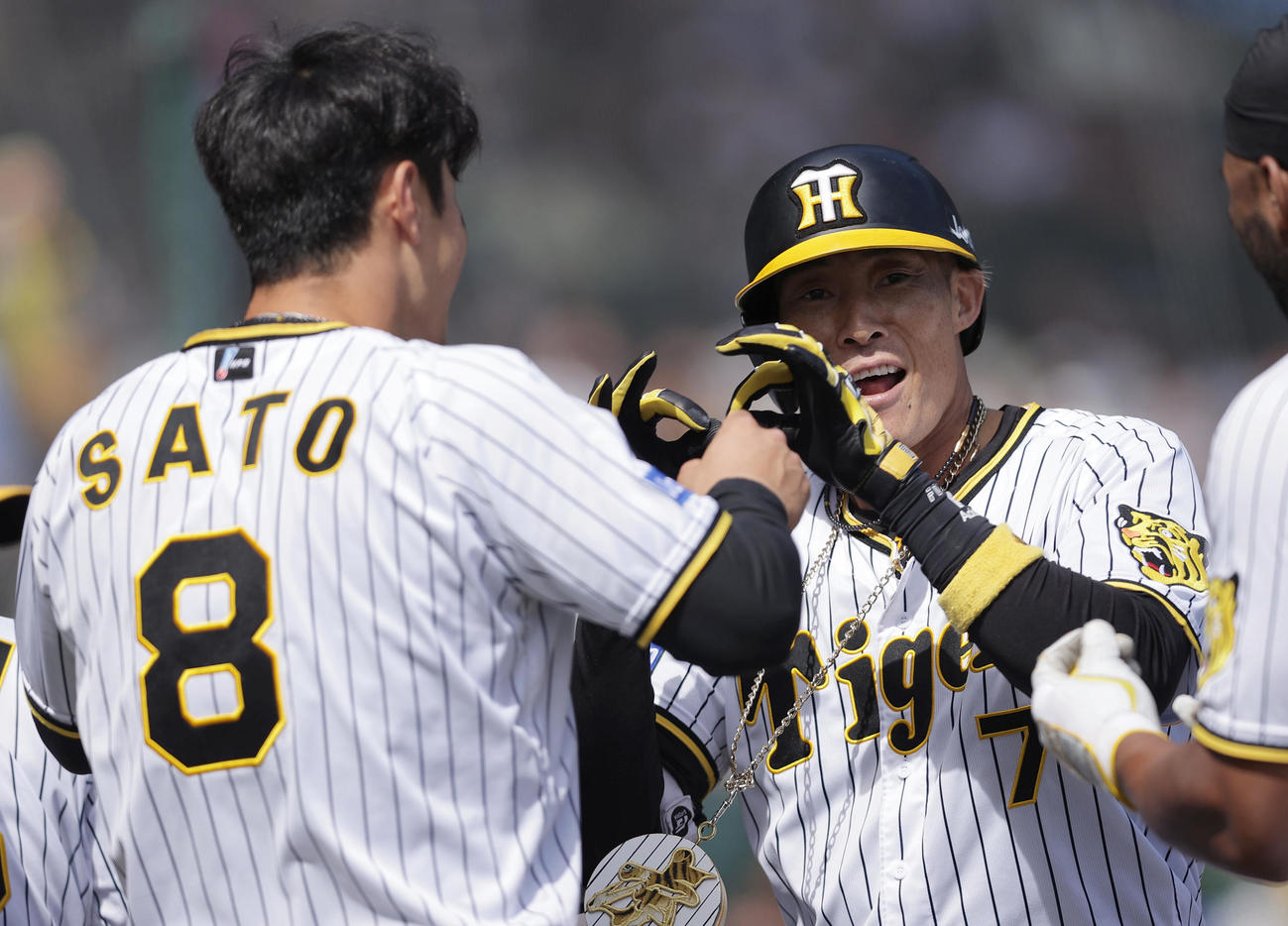 中越えに本塁打を放ち、迎えた佐藤輝（左）とパフォーマンスする糸井（2022年4月17日撮影）