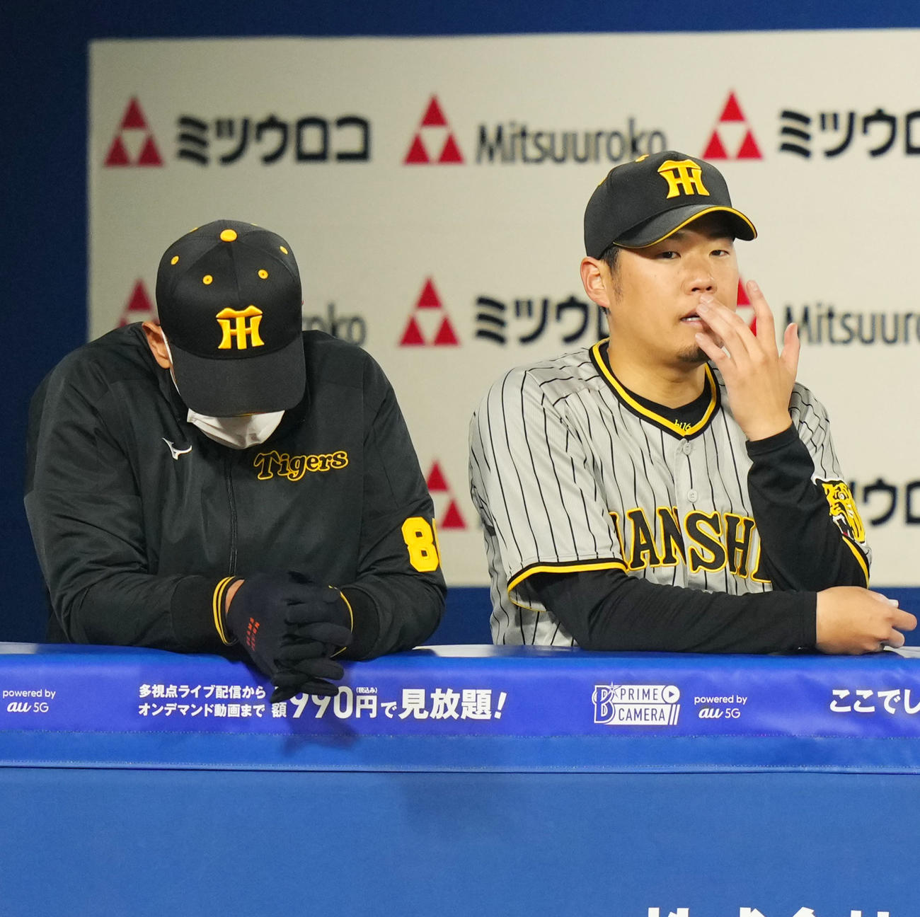 5回裏途中で降板しベンチから試合を見つめる阪神西（右）。左はうつむく矢野監督（撮影・横山健太）
