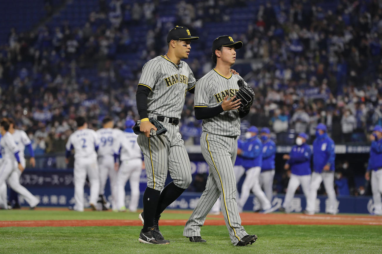 DeNA対阪神　10回裏DeNA無死、ソトに右越えサヨナラ本塁打を浴び、喜ぶDeNAナインを背に引き揚げる阪神浜地。左は肩に手をやり声をかける佐藤輝（撮影・前田充）