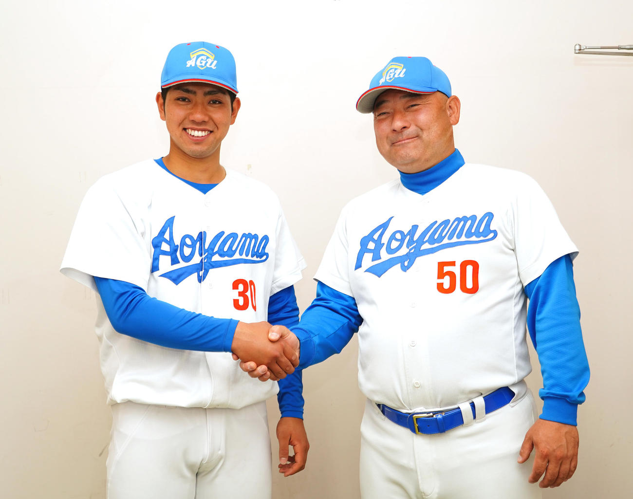 駒大に勝利し、適時二塁打を放った青学大・片山は、安藤監督（右）から握手で祝福される（撮影・菅敏）