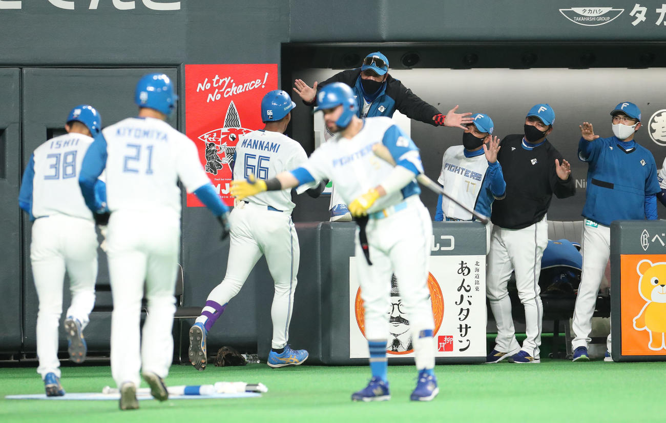 日本ハム対ソフトバンク　1回裏日本ハム2死一、三塁、左越え3点本塁打を放った万波を笑顔で出迎える新庄監督（中央後方）（撮影・佐藤翔太）