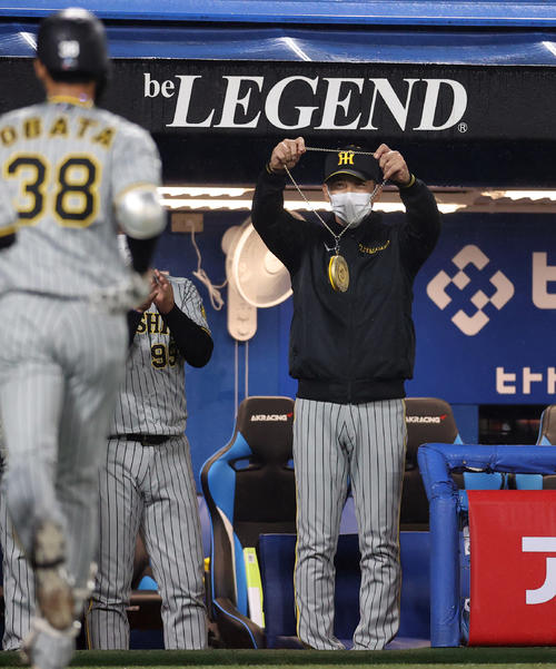 ヤクルト対阪神　7回表阪神2死二塁、2点本塁打を放った阪神小幡（手前）にメダルをかけようと笑顔で待ち構える矢野監督（撮影・狩俣裕三）