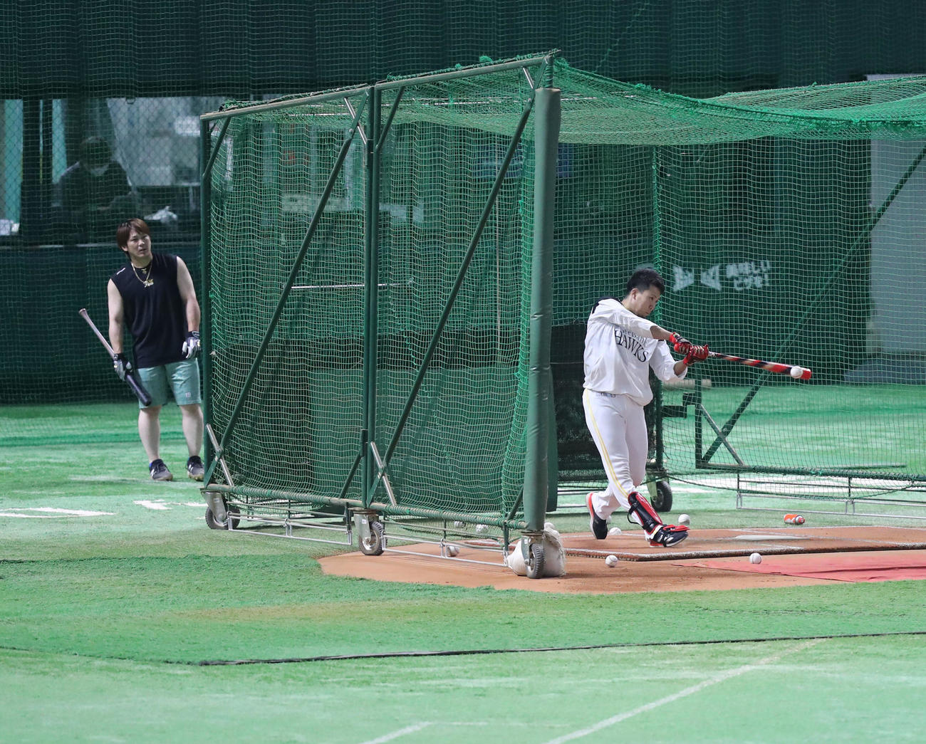 打撃練習をする千賀（右）とそれを見つめる甲斐（撮影・屋方直哉）
