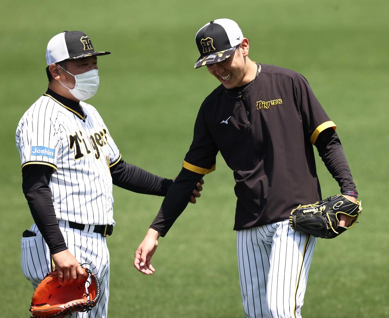 片山ブルペン捕手（左）は小川の右ヒジを確認する（撮影・上田博志）