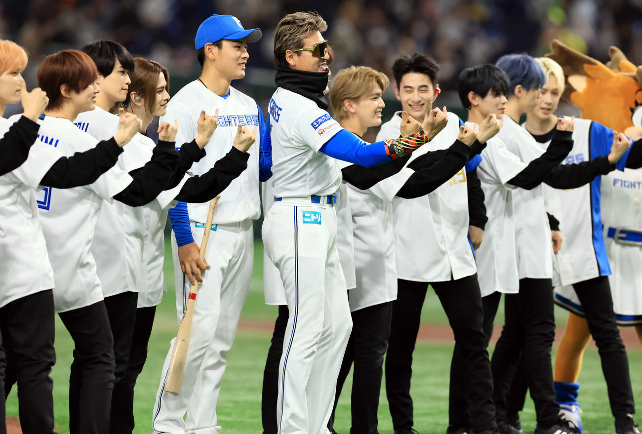 日本ハム対オリックス　ファーストピッチセレモニーに登場したINIのメンバーとポーズをとって記念撮影する日本ハム新庄監督（中央）。中央左は野村（撮影・浅見桂子）