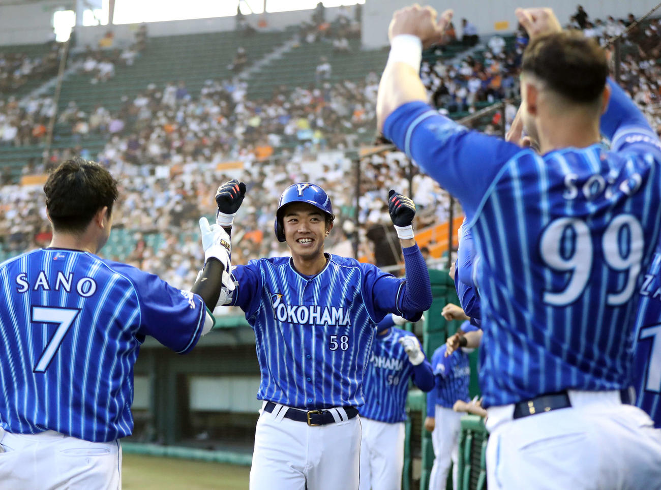 12日、巨人戦の3回、プロ初本塁打となる2点本塁打を放ち、ナインに迎えられるDeNA梶原（中央）
