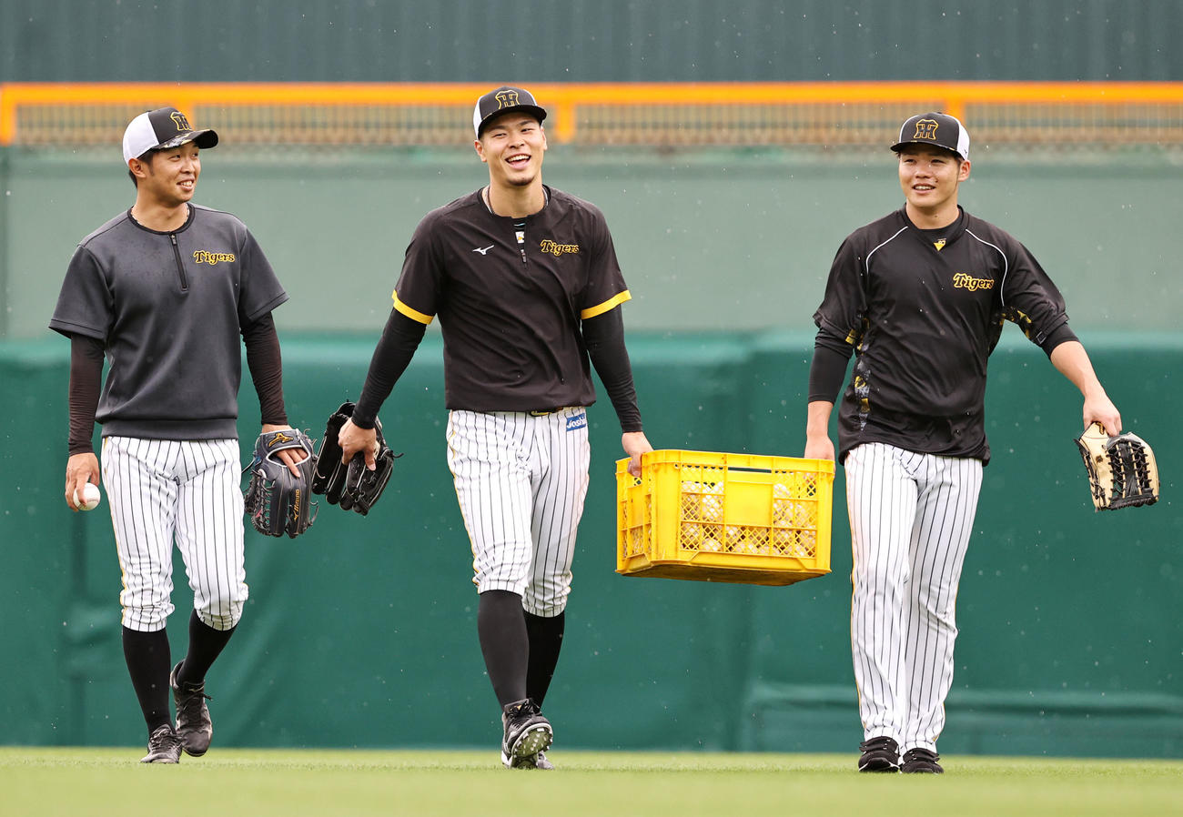 守備練習を終え佐藤輝明（中央）と小野寺暖（右）はボールの入ったカゴを持ち帰る。左は島田海吏（撮影・加藤哉）