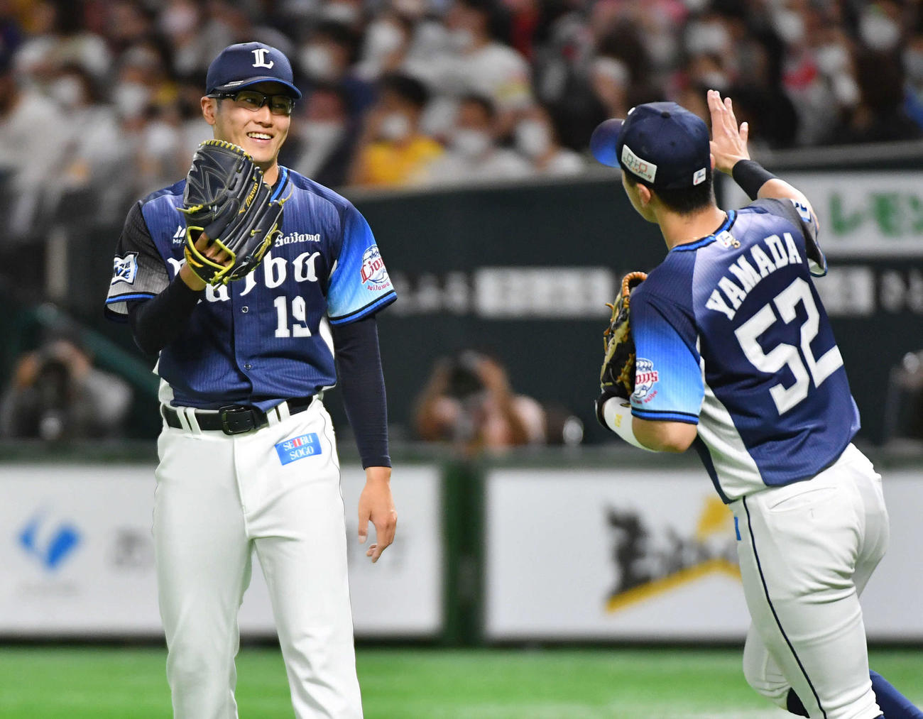 5回裏ソフトバンク1死、松田のゴロを好守した山田（右）と笑顔でタッチを交わす佐藤（撮影・岩下翔太）