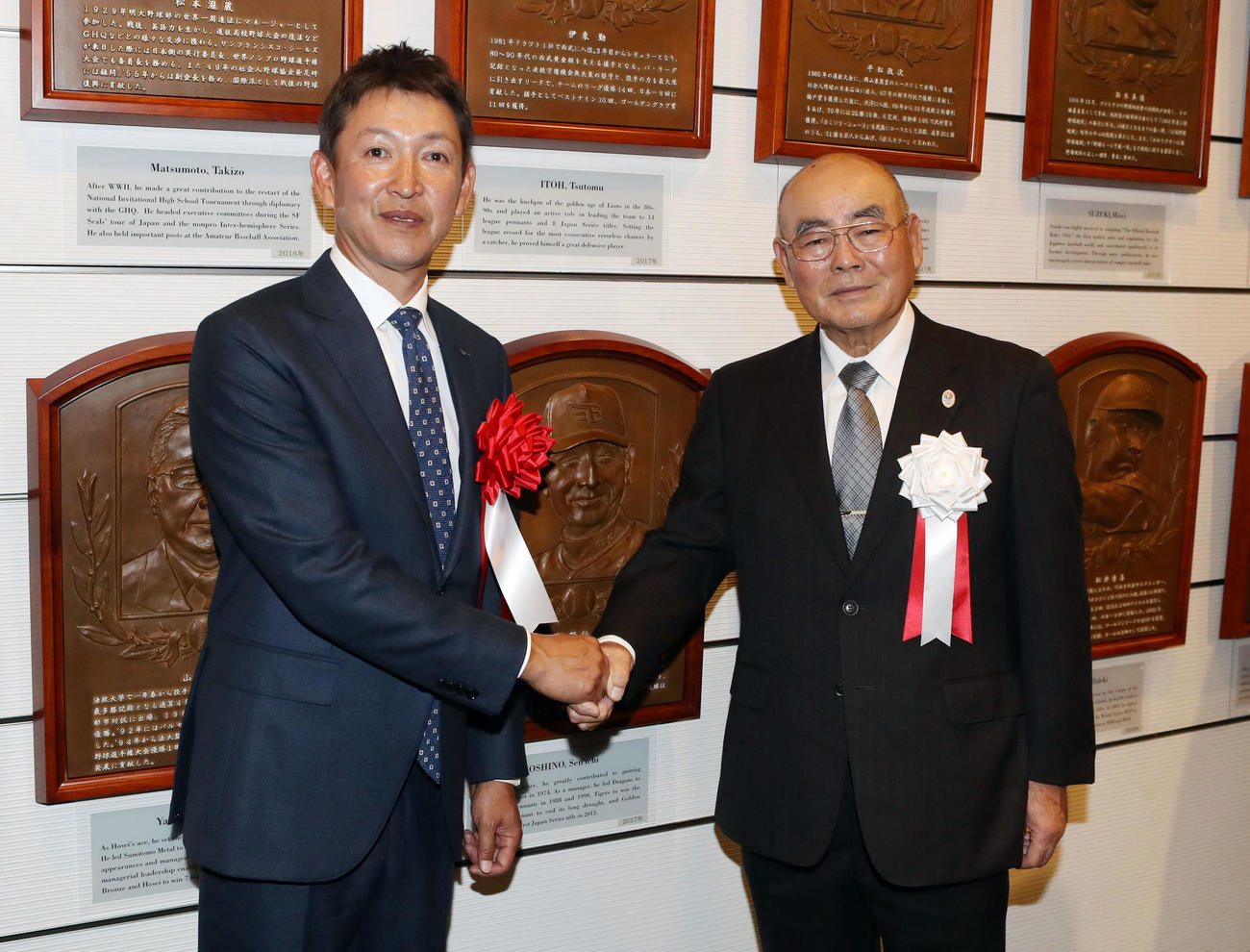 19年1月、野球殿堂入り通知式で故星野氏のレリーフを囲み、元PL学園監督の中村氏（右）と握手を交わす立浪氏